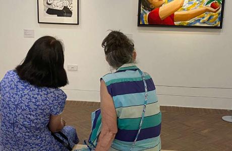 Two people sat in front of art exhibition