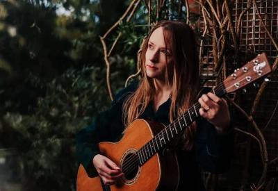 Live Music: Amy Goddard - Amy Goddard standing with guitar