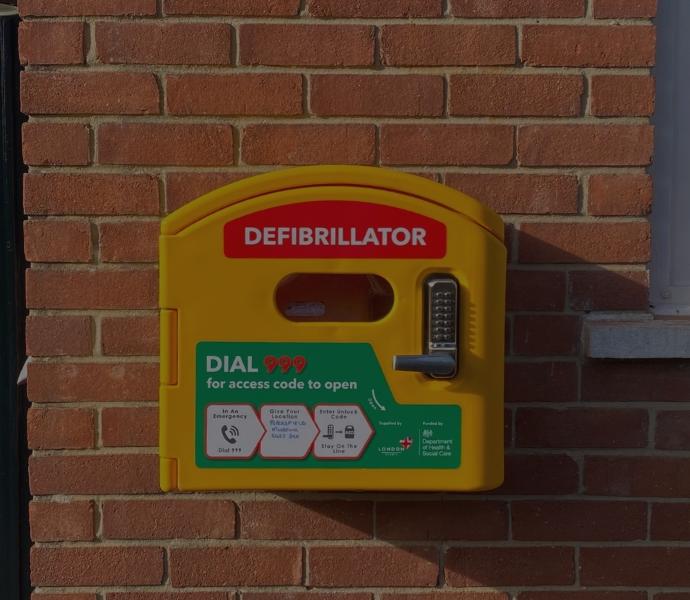 Automated external defibrillator a yellow box located on the eastern exterior brick wall of Petersfield Museum and Art Gallery.